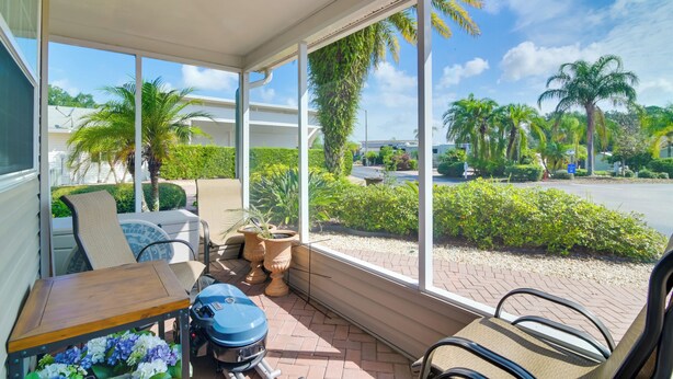 A covered outdoor seating area with a grill, chairs, and potted plants. - Quiet Davenport Home w/ Community Amenities! (Davenport)