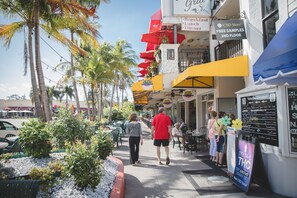 A street with outdoor seating, palm trees, and a CBD store offering free samples on the second floor. - Wonderful Vacation Home Near Siesta Key Beach (Sarasota)
