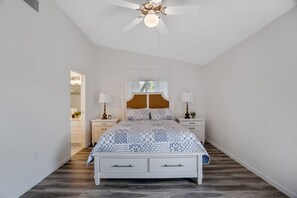 A bedroom with a bed, nightstands, a ceiling fan, and a window with curtains. - Wonderful Vacation Home Near Siesta Key Beach (Sarasota)