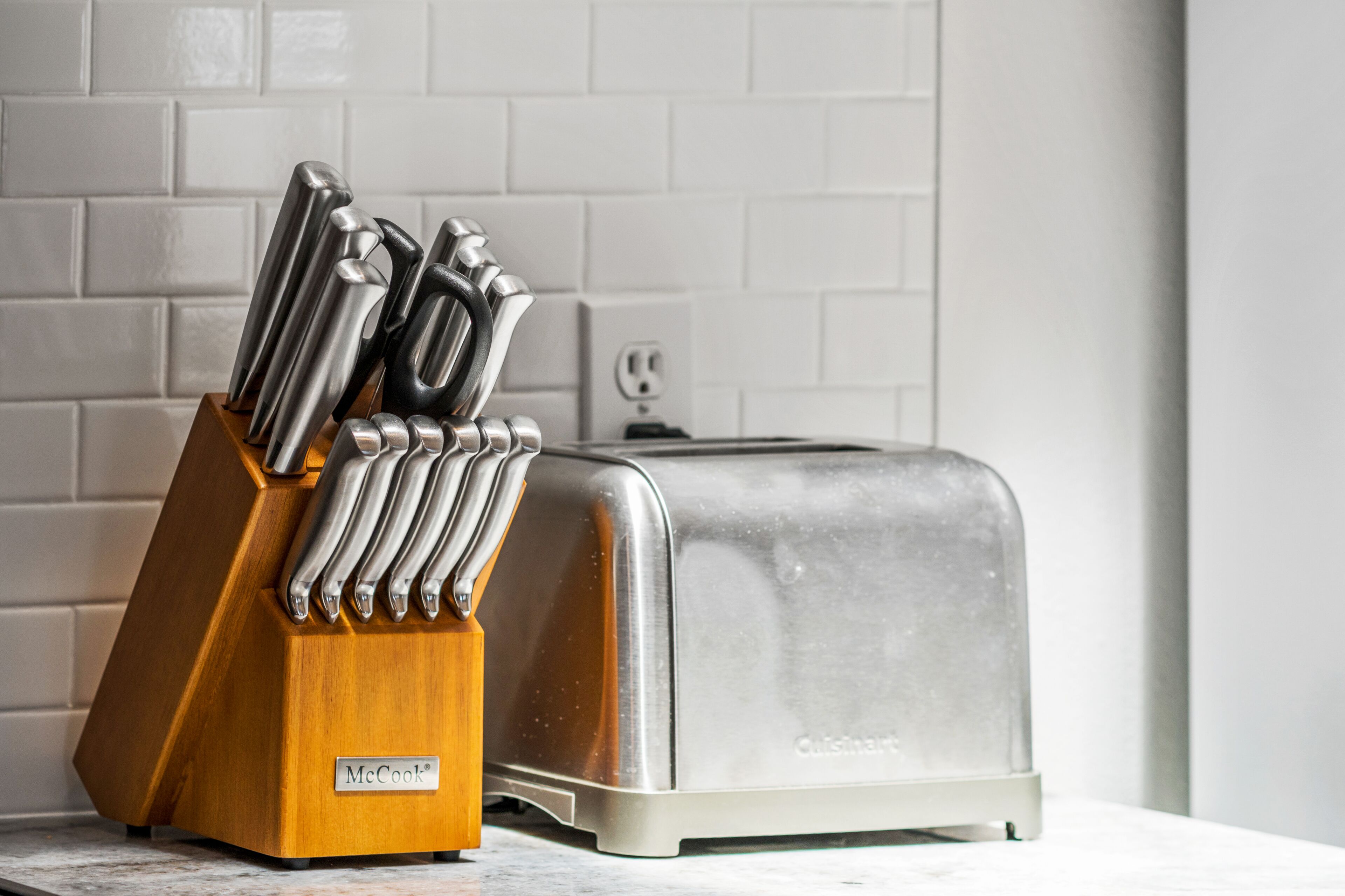 Une cuisine avec un grille-pain et un bloc à couteaux sur le plan de travail.