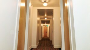 A narrow, well-lit hallway with a patterned carpet, leading to a door marked with the number 201. - Stylish Downtown Loft 201-Alaska Railroad Suite (Anchorage)