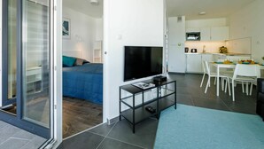 Eine moderne Wohnung mit Wohnbereich, Schlafzimmer und Küche.