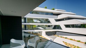 Ein modernes Gebäude mit mehreren Ebenen, großen Fenstern und einem Glasgeländer.