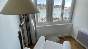 A bedroom with a large window, a bed, a lamp, and a radiator. - Seaview, Ocean view, villa on the historical harbor, city center (Pornic)