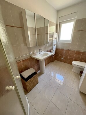 A bathroom with a sink, mirror, toilet, and a window. - Seaview, Ocean view, villa on the historical harbor, city center (Pornic)