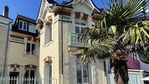 A two-story building with a balcony, a palm tree in front, and a clear blue sky. - Seaview, Ocean view, villa on the historical harbor, city center (Pornic)
