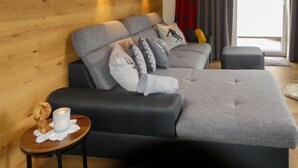 A modern bedroom with a sofa bed, a small table with a candle, and a window with curtains. - Wildkogel by Interhome (Neukirchen am Großvenediger)
