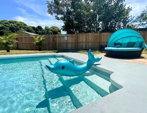 A swimming pool with a dolphin floatation device.