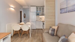 A compact living space with a kitchenette, a dining area, and a sofa.