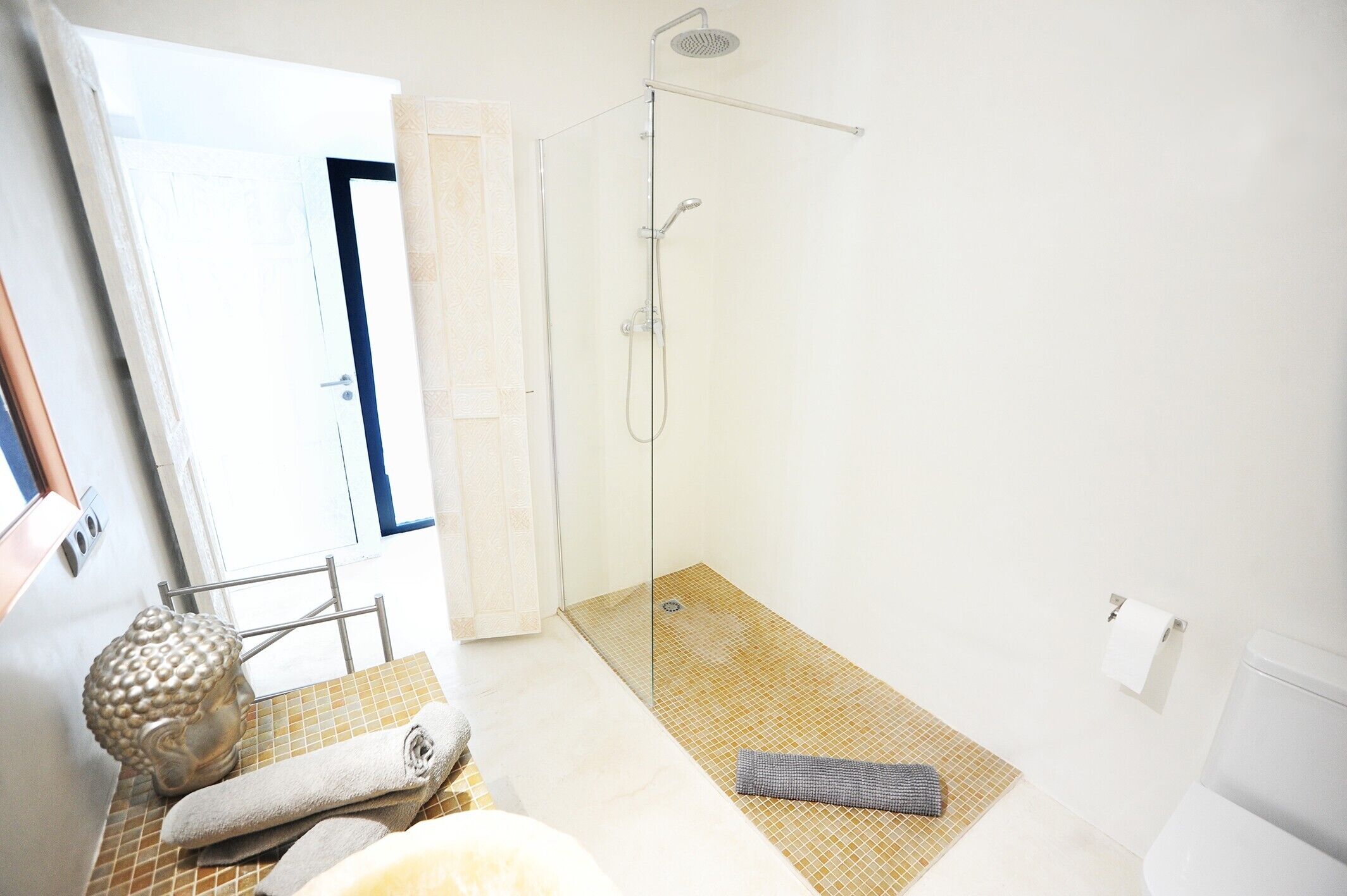 Un baño con ducha, inodoro y toallero.