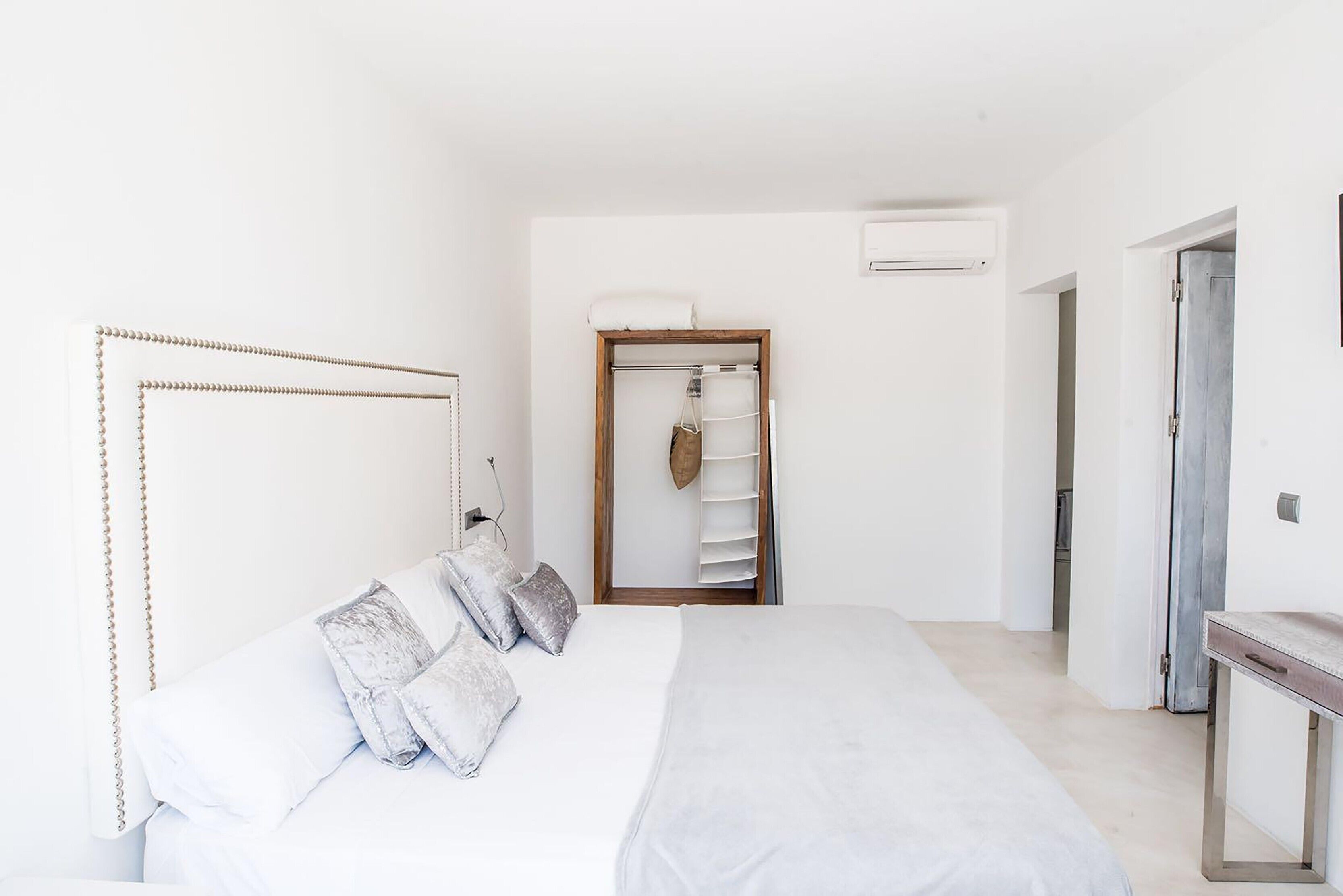 Een slaapkamer met een bed, een kledingkast en een klein tafeltje.