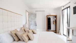 Ein Schlafzimmer mit einem großen Bett, einem Kleiderschrank und einem Fenster.