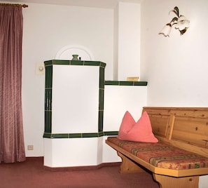 A room with a wooden bench, a mirror with a green frame, and a wall-mounted decorative item. - Kaiser Apartment in a Central Location (Reit im Winkl)