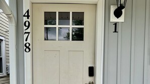 En vit dörr med numret 4978 på vänster sida och en svart lykta på höger sida.