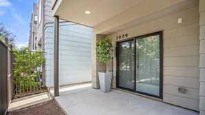 A modern building with a large sliding glass door, a potted plant, and a number '2809' on the wall. - Ethereal Rooftop Retreat - 1 km from FIFA Fest (Houston)