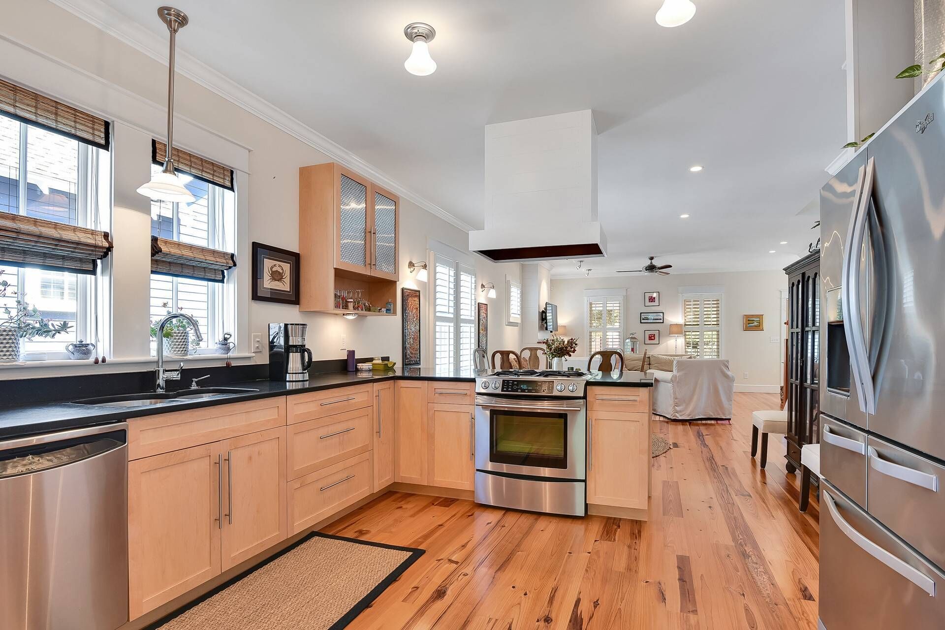 Une cuisine moderne avec des meubles en bois, des appareils en acier inoxydable et un grand îlot central.