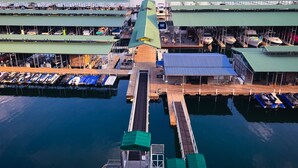A marina with boats docked, a covered walkway, and a view of the surrounding landscape.