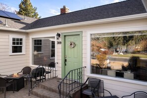 A house with a green door, number 309, and a patio with outdoor furniture. - Historic Drake Cottage 30 Day Rental. Across from Drake Park, Mirror Pond, downtown Bend. Furnished. (Bend)