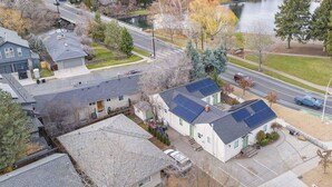 An aerial view of a residential area with houses, a road, and a lake. - Historic Drake Cottage 30 Day Rental. Across from Drake Park, Mirror Pond, downtown Bend. Furnished. (Bend)