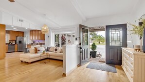 A spacious living room with a sofa and a dining area. A kitchen is visible in the background. - Private Corner Oasis with Heated Saltwater Pool (Palm Coast)