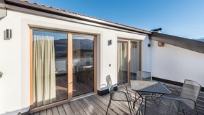 A balcony with a table and chairs, a sliding glass door, and a view of the outdoors. - Apartment "Guntschöllerhof Hochwart" with Mountain View, Wi-Fi, Balcony & Garden (Völs)