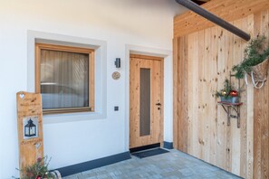Une porte en bois, une fenêtre et une pancarte de bienvenue.