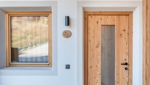 A wooden door with a keyhole and a small plaque on the wall. - Apartment "Guntschöllerhof Hochwart" with Mountain View, Wi-Fi, Balcony & Garden (Völs)