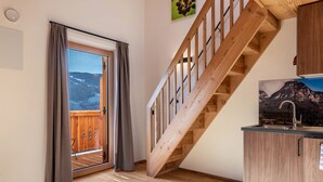 A wooden staircase leading to a balcony with a view of mountains. - Apartment "Guntschöllerhof Völseggspitze" with Mountain View, Wi-Fi, Balcony & Garden (Völs)