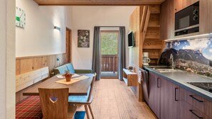 Une cuisine moderne avec des meubles en bois, un four à micro-ondes encastré et une grande fenêtre.