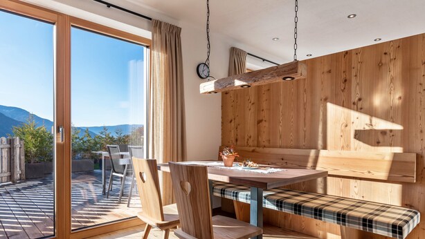 Ein moderner Essbereich mit einer Holzbank, einem Tisch und Stühlen.