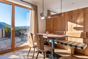 Un espace repas moderne avec un banc en bois, une table et des chaises.