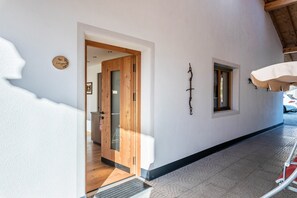 A hallway with a wooden door, a small window, and a wall-mounted light fixture. - Apartment "Guntschöllerhof Laugen" with Mountain View, Wi-Fi, Balcony & Garden (Völs)