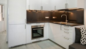 A modern kitchen with white cabinets, a black countertop, a stainless steel sink, and an oven. - Apartment "Casa Princesa" with Sea & Mountain View, Pool, Balcony & Wi-Fi (Playa del Cura)