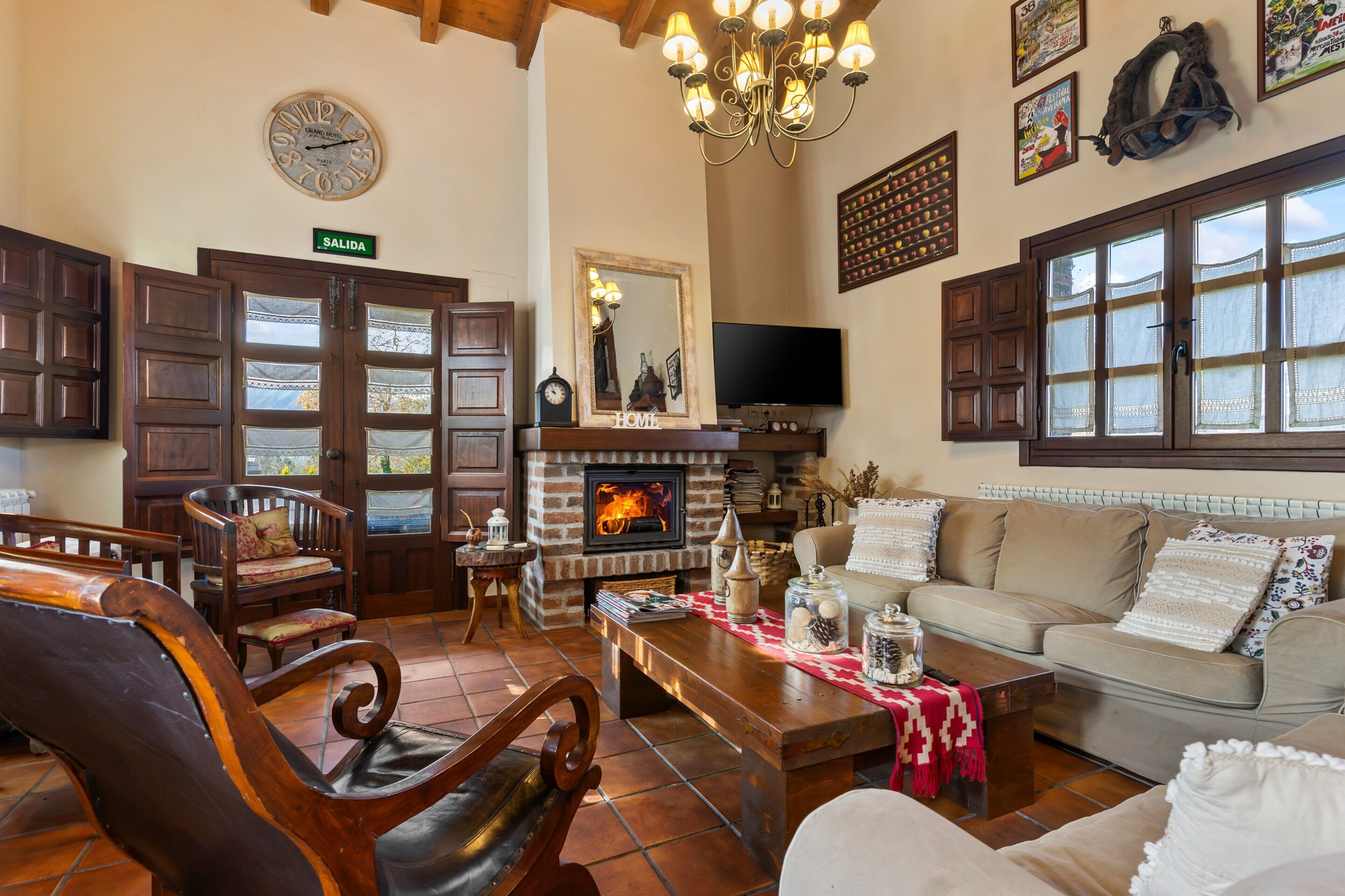 Una sala de estar acogedora con chimenea, muebles de madera, un sofá y un televisor.