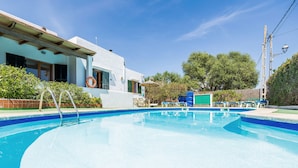 A swimming pool with a metal ladder, lounge chairs, and a building with large windows and a lifebuoy. - Felipe 1-4 Apartment with Terrace, Shared Pool & Wi-Fi (Tourist Taxes Included) (cala dor)