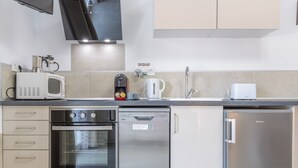 Een moderne keuken met een inbouwoven, vaatwasser en koelkast.