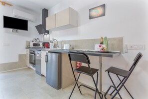A compact kitchen with a microwave, coffee maker, and a small refrigerator.