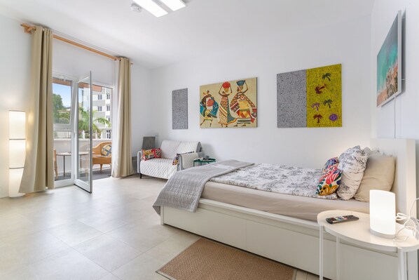 Une chambre à coucher moderne avec un lit, une table de chevet et des œuvres d’art accrochées aux murs.