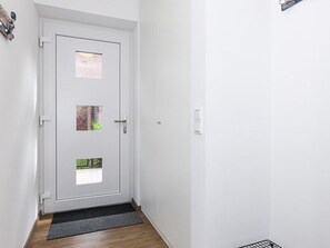 A white door with a small window and a doormat. - Vacation Home in Meer, Germany (Dornum)