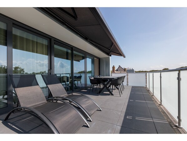 Relax and socialize in this outdoor space with curved lounge chairs and a small table, offering a view of the surrounding landscape.