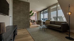 Una sala de estar moderna con un sofá, una mesa de centro y un televisor montado en la pared.