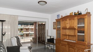 A living room with a sofa, a wooden cabinet, and a television. - ESTRELLA, 2º-10 (Cullera)