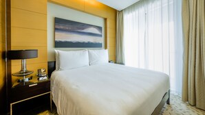 Una camera d'albergo con un letto grande, una scrivania con una lampada, un telefono e un quadro appeso al muro.