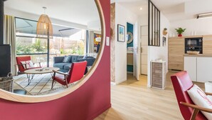 Een moderne woonkamer met een grote spiegel, een eethoek en een keuken.
