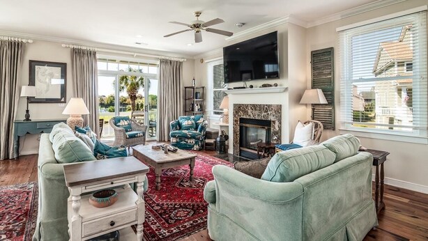 A spacious living room with a fireplace, comfortable seating, and a large TV. - Coastal Retreat at The Rookery: 4 BDRM Home (Pawleys Island)