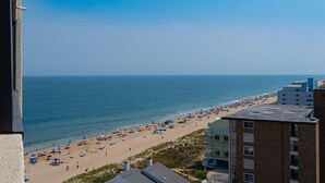 A beach with buildings in the foreground. - Beautiful sunset and ocean view from 2 Bedroom Condo with Free WiFi and an Outdoor Pool Located in Midtown Only Steps to Beach! Vacation at the Shore with Shoreline Properties (Ocean City)