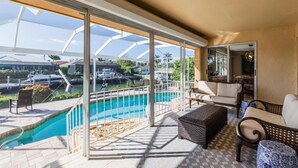 Un balcón amplio con piscina, mobiliario exterior y vistas del entorno.