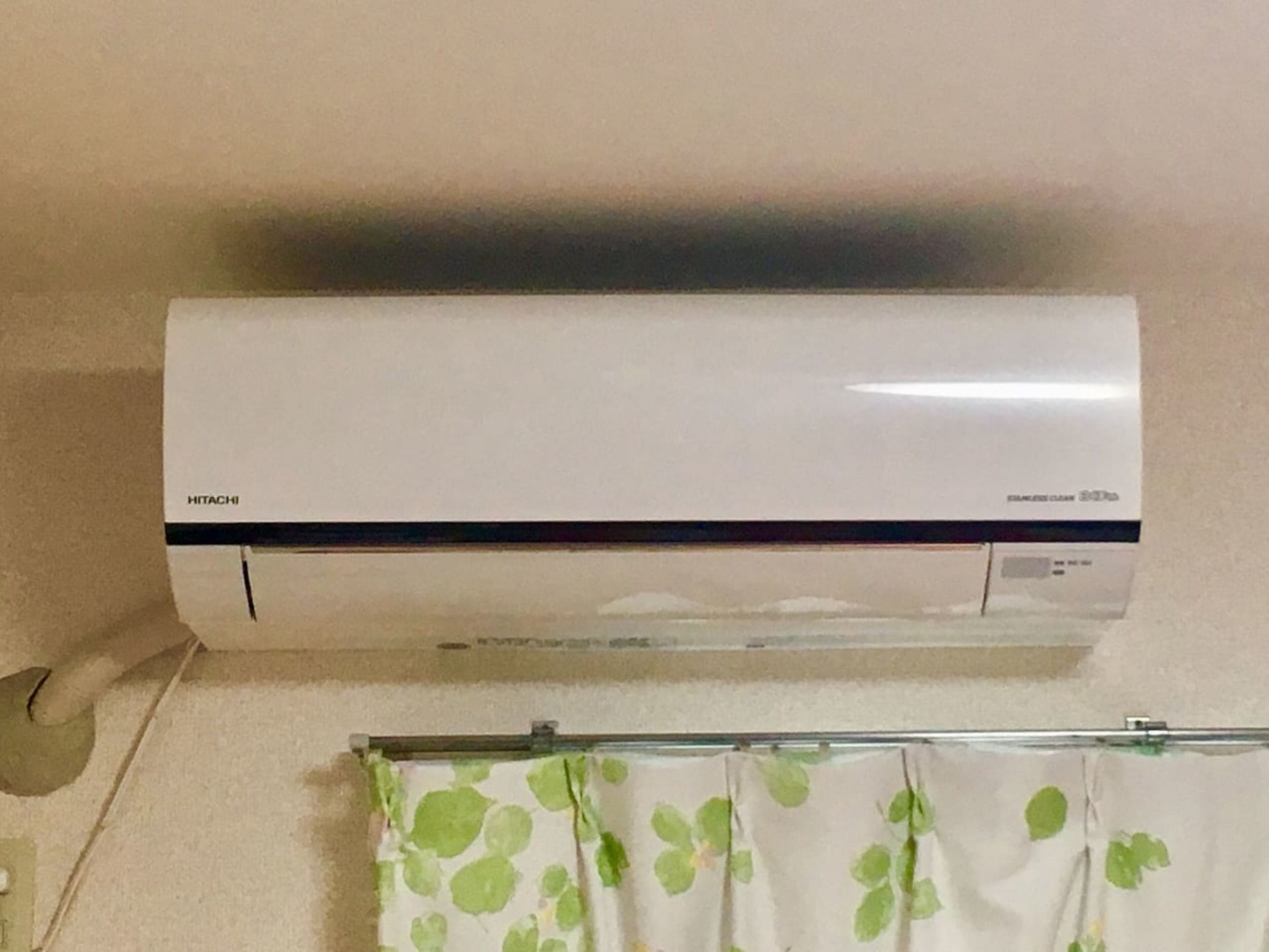 Un climatiseur mural doté d’un panneau de commande et d’un câble d’alimentation.