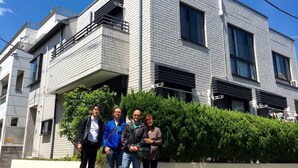 A modern multi-story building with a brick facade, balconies, and large windows. - Y's B&Kitchen Tokyo HY1 (Tokyo)