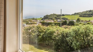 A view from a window overlooking a rural landscape with houses, greenery, and a clear sky. - Ty Bedw (Tyn-y-Gongl)
